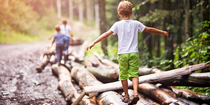 Children balancing on tree trunks